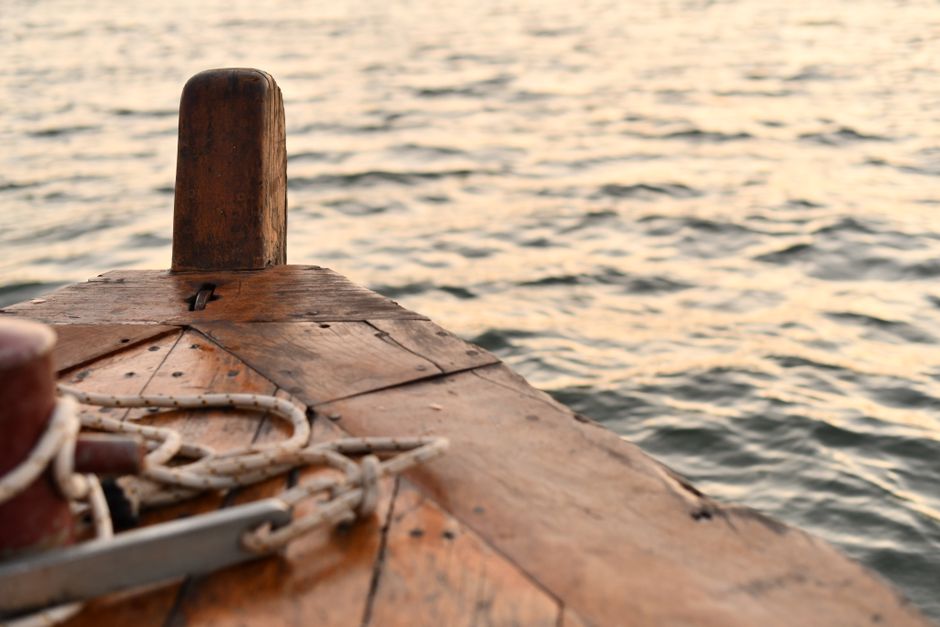 Wooden boat bow with rope in golden evening light